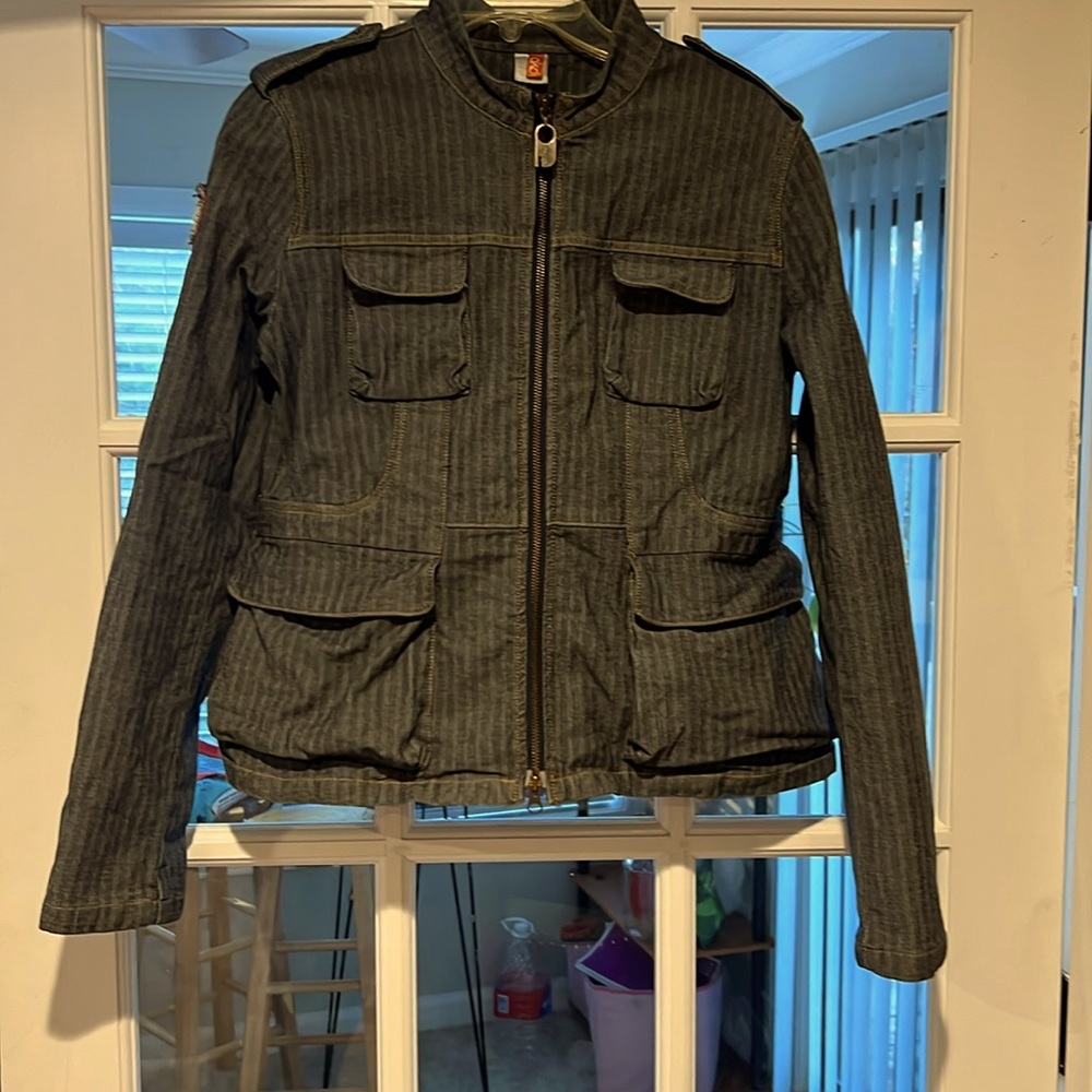 Akdmks jacket with shoulder buttons and sleeve zippers.